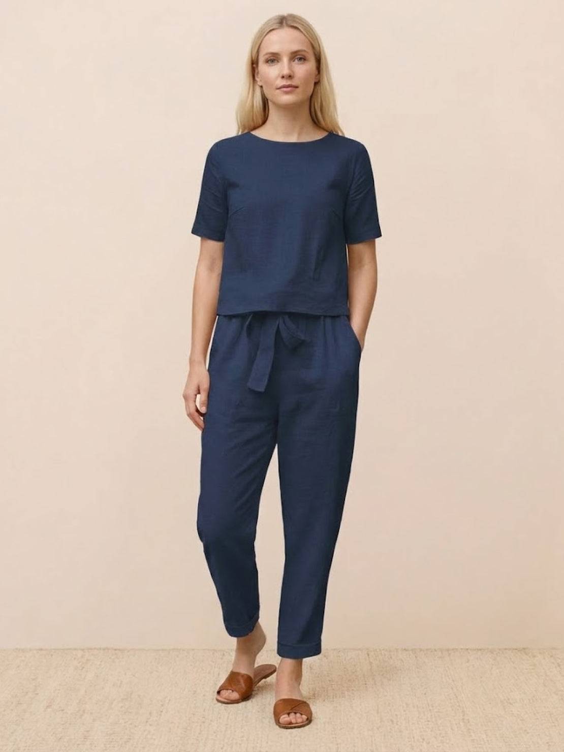 Woman wearing relaxed 100% cotton linen set with short-sleeve top and straight-leg pants in monochrome tone