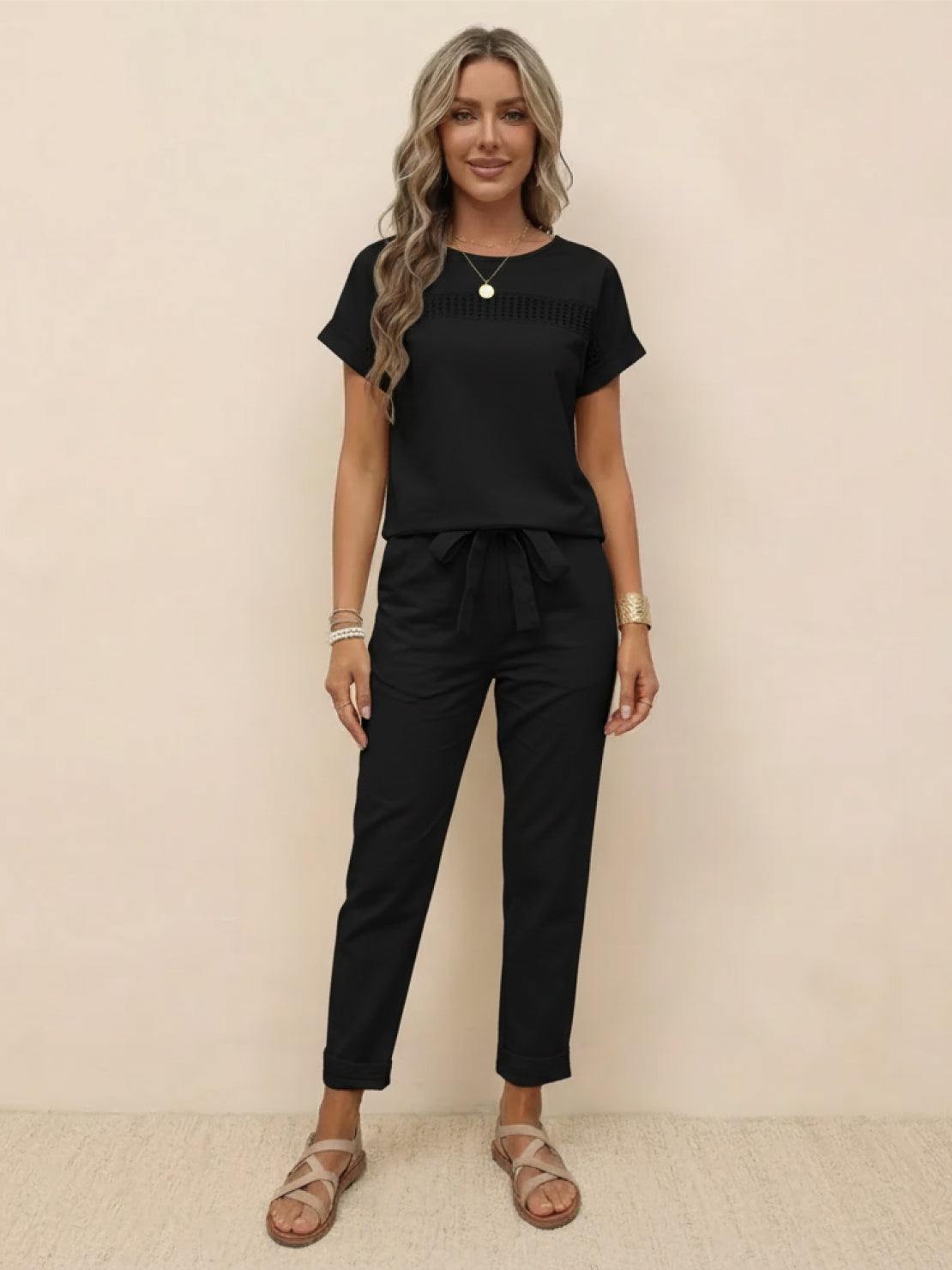 Woman wearing black 100% cotton total comfort two-piece travel set with short sleeves and drawstring pants