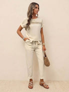 woman wearing 100% cotton total comfort two-piece travel set with short sleeves and drawstring pants carrying woven bag