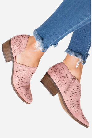 Pink laser cut western ankle boots with low block heels and side zipper worn with frayed hem jeans