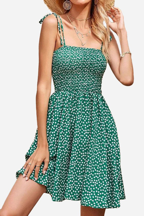Green bohemian skater mini dress with white polka dots and sling knot straps designed for summer.
