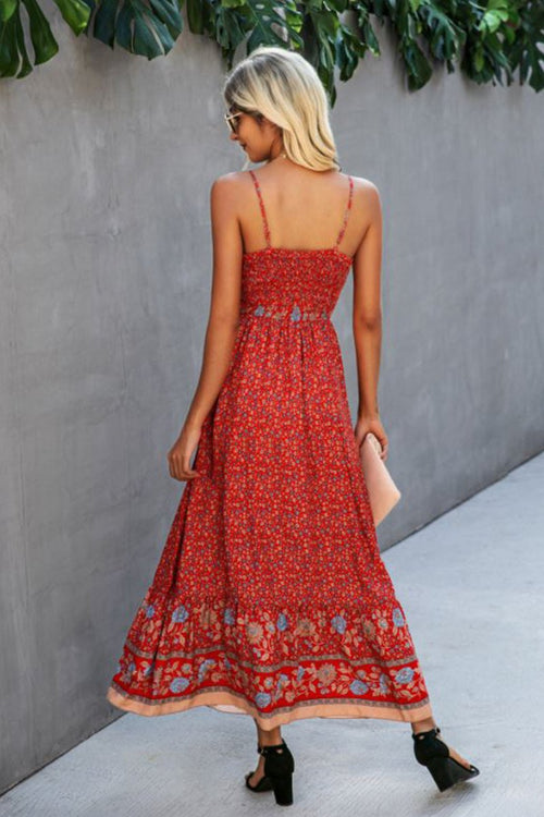 Woman wearing a red vintage flower prints maxi dress with spaghetti straps and open back standing outdoors
