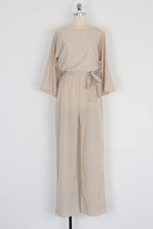 Beige casual long sleeve belted jumpsuit with batwing sleeves and round neck on mannequin