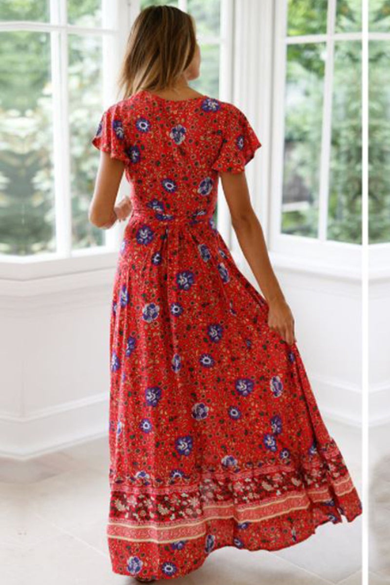 Woman wearing red Bohemian floral print wrap dress with ruffle hem indoors