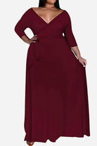 Elegant plus size dress with deep V-neck, 3/4 sleeves, belted waist, and swing skirt in solid burgundy color.