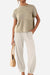 Woman wearing beige Comfy Couture Knit Sweater two-piece set with knit pullover and high-waisted pants, holding a woven handbag.