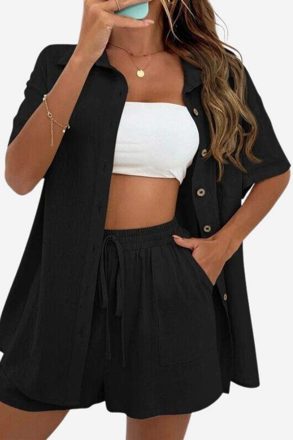 Woman wearing black Sunny Day Vibrance two-piece set with shorts and button-up shirt over white crop top