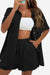 Woman wearing black Sunny Day Vibrance two-piece set with shorts and button-up shirt over white crop top