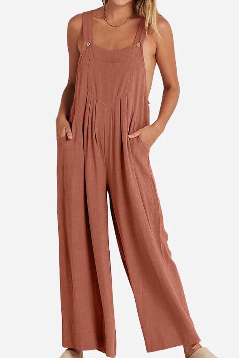 Woman wearing rust-colored Free-Flow Wide Leg Overalls with adjustable straps and a loose fit.
