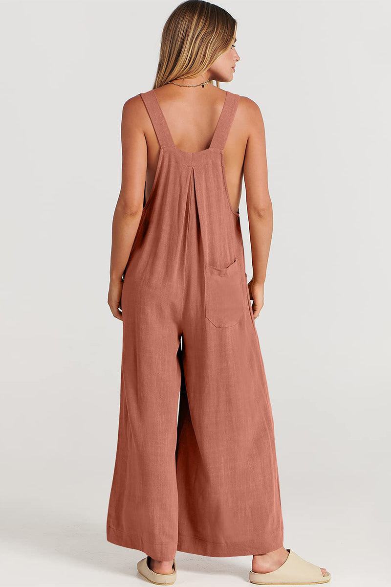 Back view of a woman wearing rust-colored Free-Flow Wide Leg Overalls with wide straps and loose fit.
