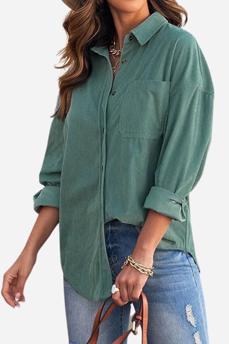 Woman wearing green sleek suede oversized button-down shirt with rolled-up sleeves and blue ripped jeans