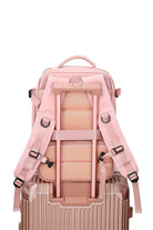 Chic Wanderlust Waterproof Backpack in pink shown attached to suitcase handle with padded ergonomic straps and breathable back panel.