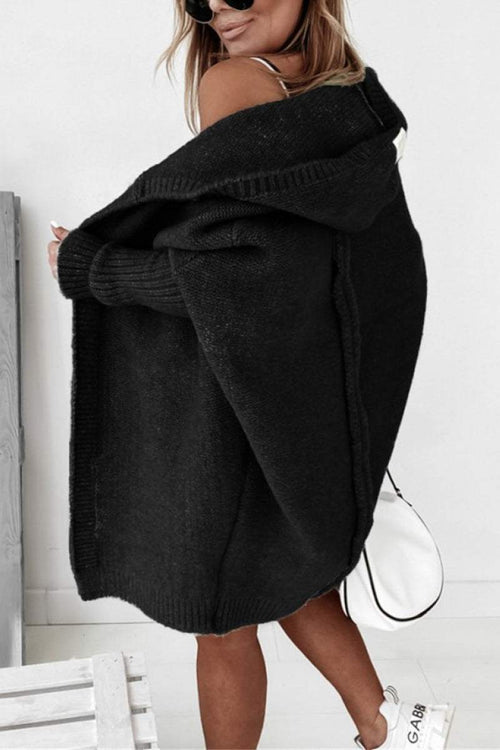 woman wearing black warm oversized hooded cardigan with relaxed fit and hood outside