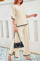 Short sleeved relaxed fit two-piece lounge set in cream with black trim, featuring a loose top and wide-leg palazzo pants.