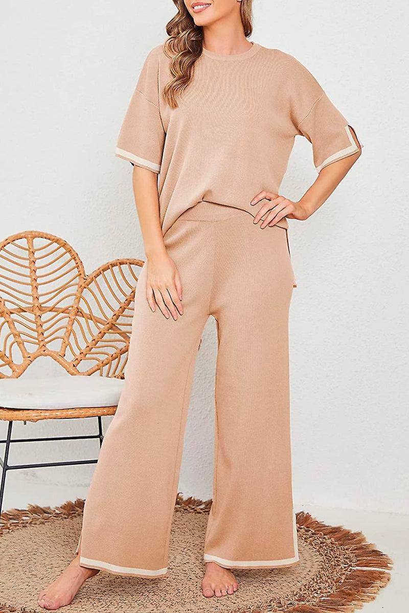 Woman wearing beige short sleeved relaxed fit lounge two-piece set with wide-leg pants standing indoors