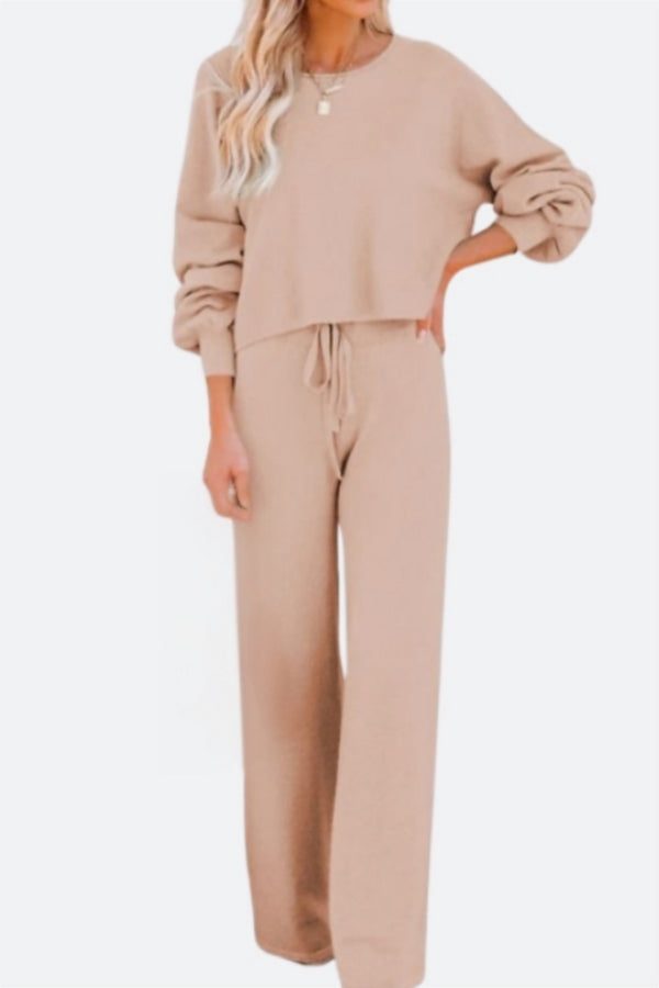 Woman wearing beige round neck loose fit cozy two-piece set with long sleeves and wide-leg pants.