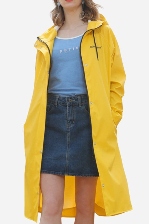 Lightweight ultra water-resistant long yellow windbreaker jacket with hood and button closure worn over casual outfit