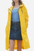 Lightweight ultra water-resistant long yellow windbreaker jacket with hood and button closure worn over casual outfit