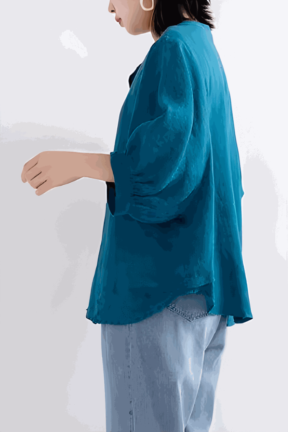 Relaxed loose breathable linen blouse in vibrant blue with long sleeves and a relaxed fit, styled with light denim jeans.