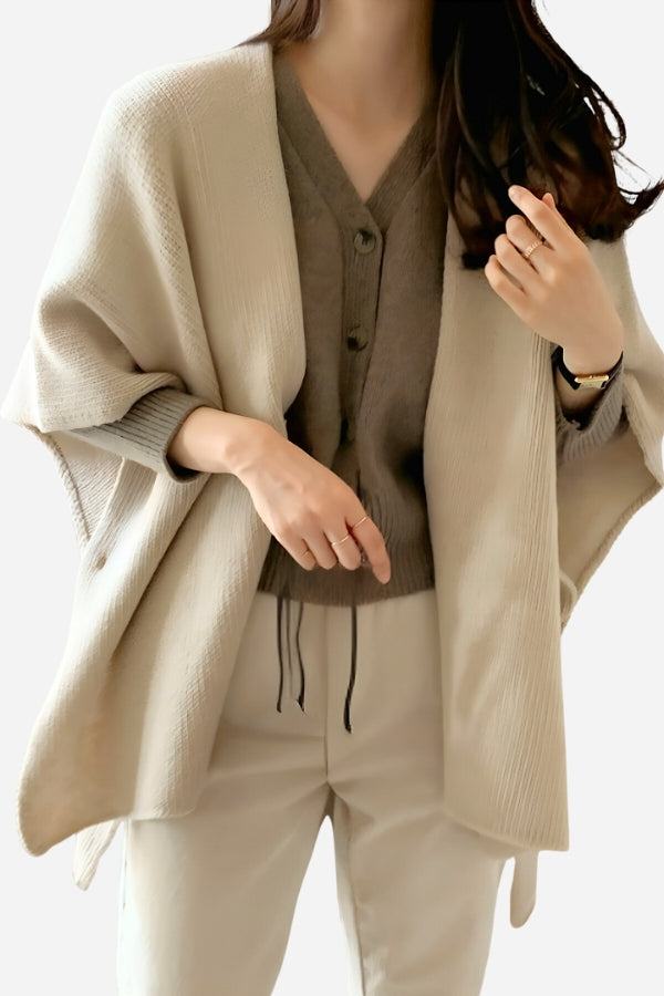 Woman wearing relaxed flowy open front knitwear cardigan in beige over taupe top and light pants