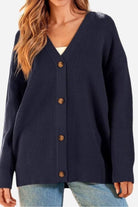 Relaxed fit oversized black knit cardigan with button-down front and long sleeves on woman