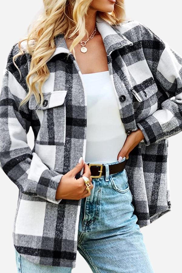 Woman wearing comfy flannel classic black and white plaid button-down shirt with chest pockets and collar over white top and denim jeans