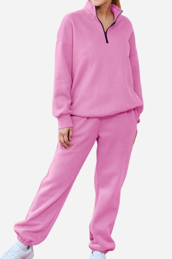 Woman wearing ultra-soft and comfy pink co-ord tracksuit set with a half-zip pullover and elastic cuff pants.