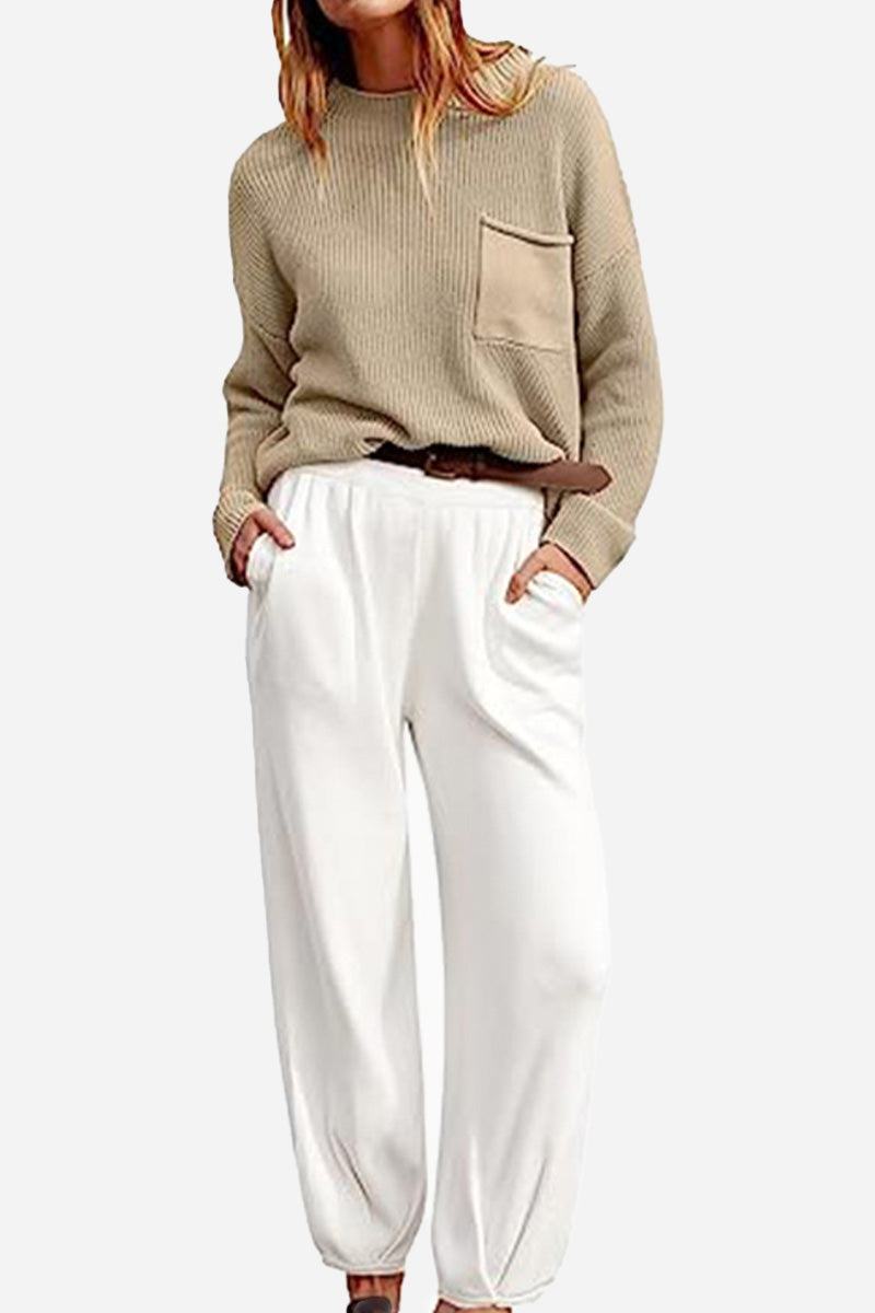 Woman wearing European minimalism relaxed beige knit sweater with pocket and white drapey trousers