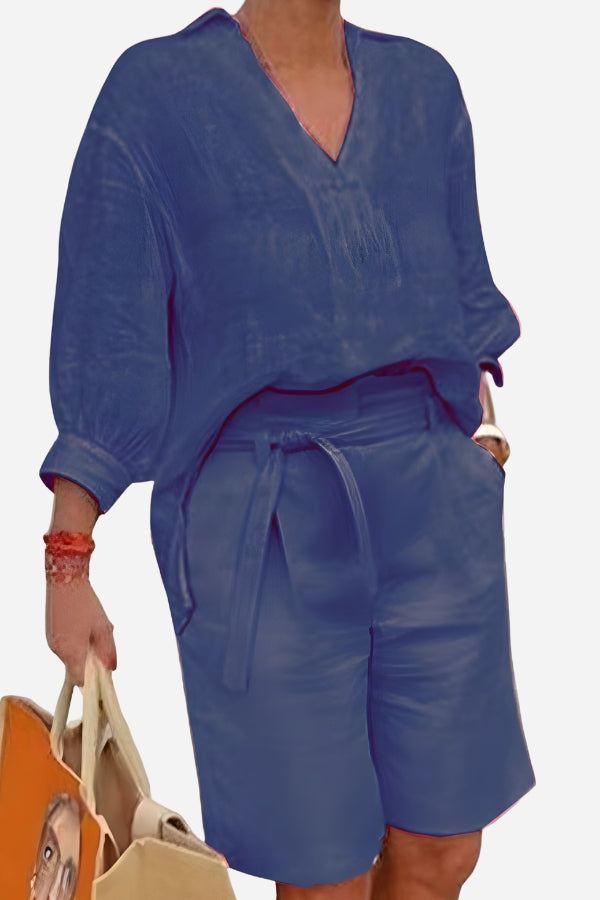 Blue two-piece set with loose V-neck shirt and high-waisted knee-length shorts with belt and pockets