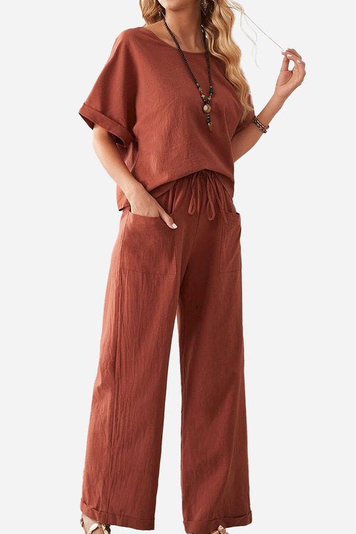 Woman wearing a rust-colored rolled cuff top and patch pocket pants set with relaxed fit and drawstring waist.
