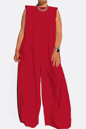 Red sleeveless wide-leg jumpsuit with sharp shoulders and long flowing legs, styled with a chunky necklace and bracelet.