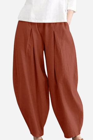 Rusty orange solid color wide leg cotton pleated pants with voluminous cut.