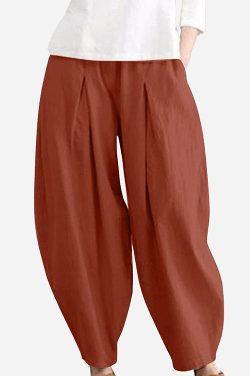 Rusty orange solid color wide leg cotton pleated pants with voluminous cut.