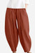 Rusty orange solid color wide leg cotton pleated pants with voluminous cut.