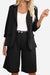 Black blazer and high-waisted shorts two-piece set with white top and belt, stylish and polished women's outfit