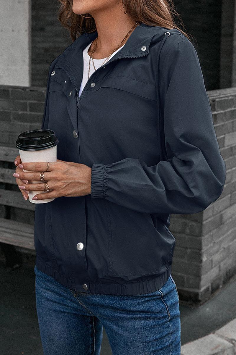 Woman wearing navy outdoor hooded raincoat windbreaker holding coffee cup