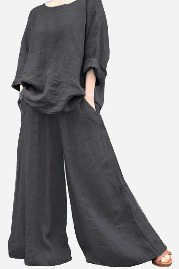 Black wide leg pants with pockets styled with a loose, rolled-sleeve top for a comfortable, chic look