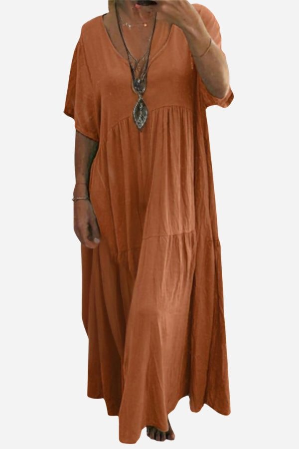Rust-colored V-neck two-tiered maxi swing dress with loose sleeves and flowing tiers, made of lightweight cotton.
