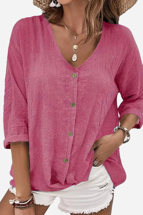pink button front tunic with rolled sleeves and v-neck neckline paired with white shorts