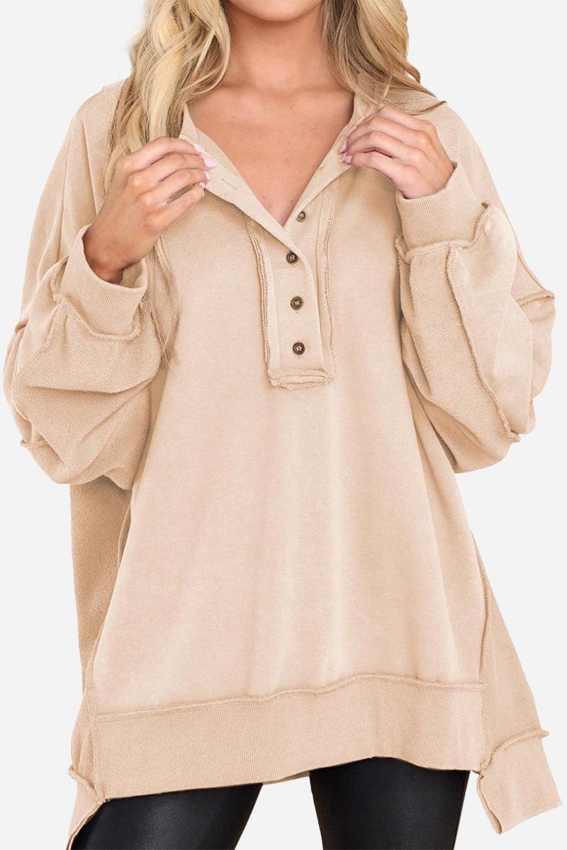Beige oversized urban sweatshirt with slouchy sleeves and buttoned Henley neckline worn by woman