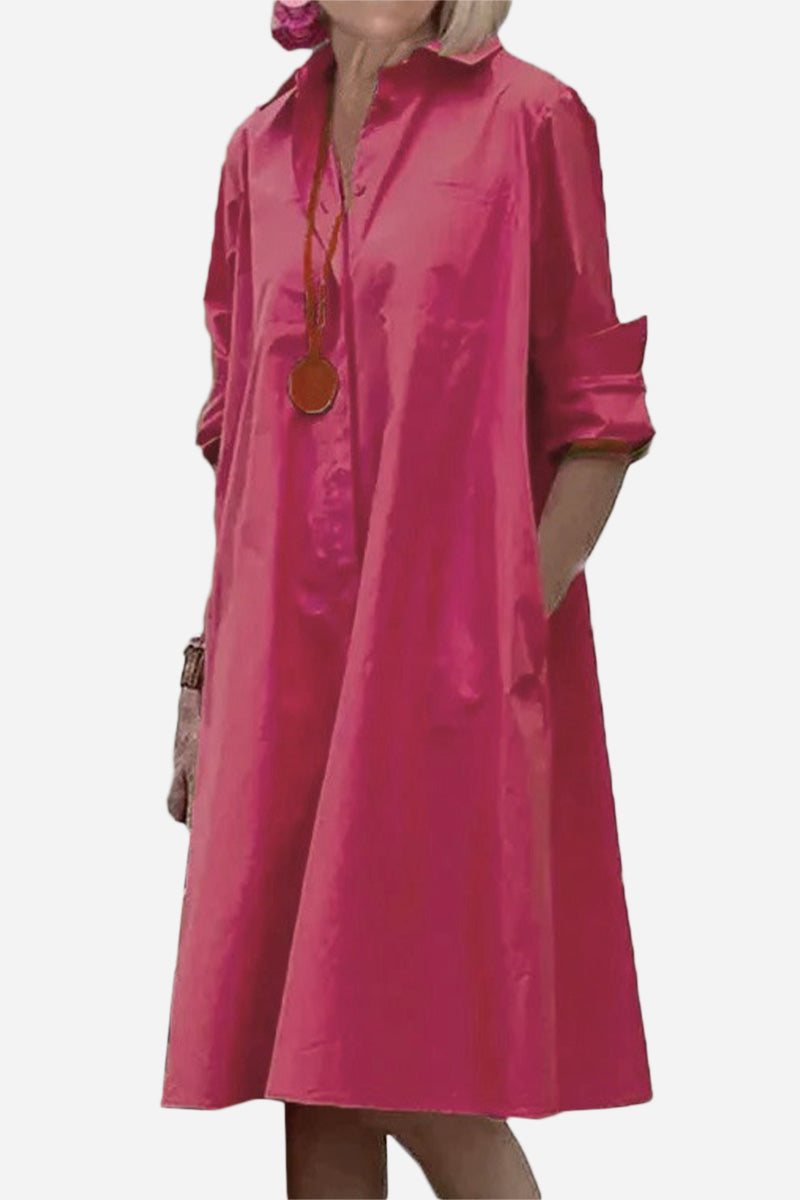 Pink long shirt-style dress with collar and rolled-up sleeves, loose fit, and pockets.