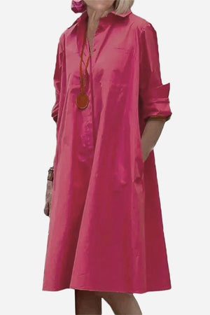 Pink long shirt-style dress with collar and rolled-up sleeves, loose fit, and pockets.