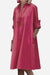 Pink long shirt-style dress with collar and rolled-up sleeves, loose fit, and pockets.