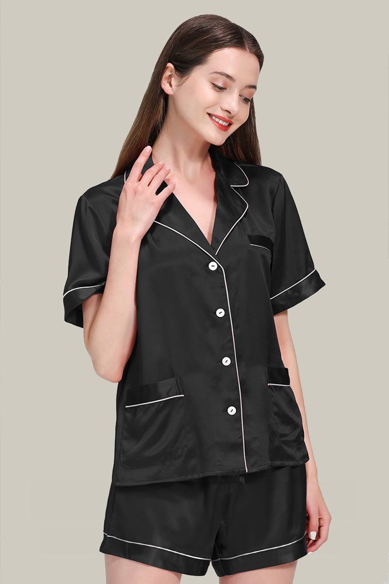 Woman wearing black Mulberry silk buttoned short set pajamas with white piping