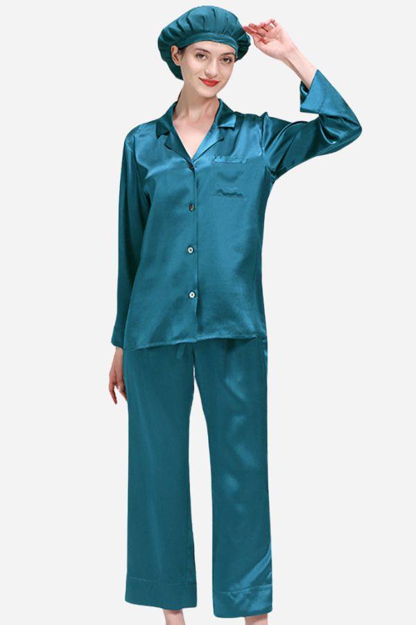 Woman wearing a teal classic mulberry silk pajama set with long-sleeve button-down top, wide-leg pants, and matching sleep cap.