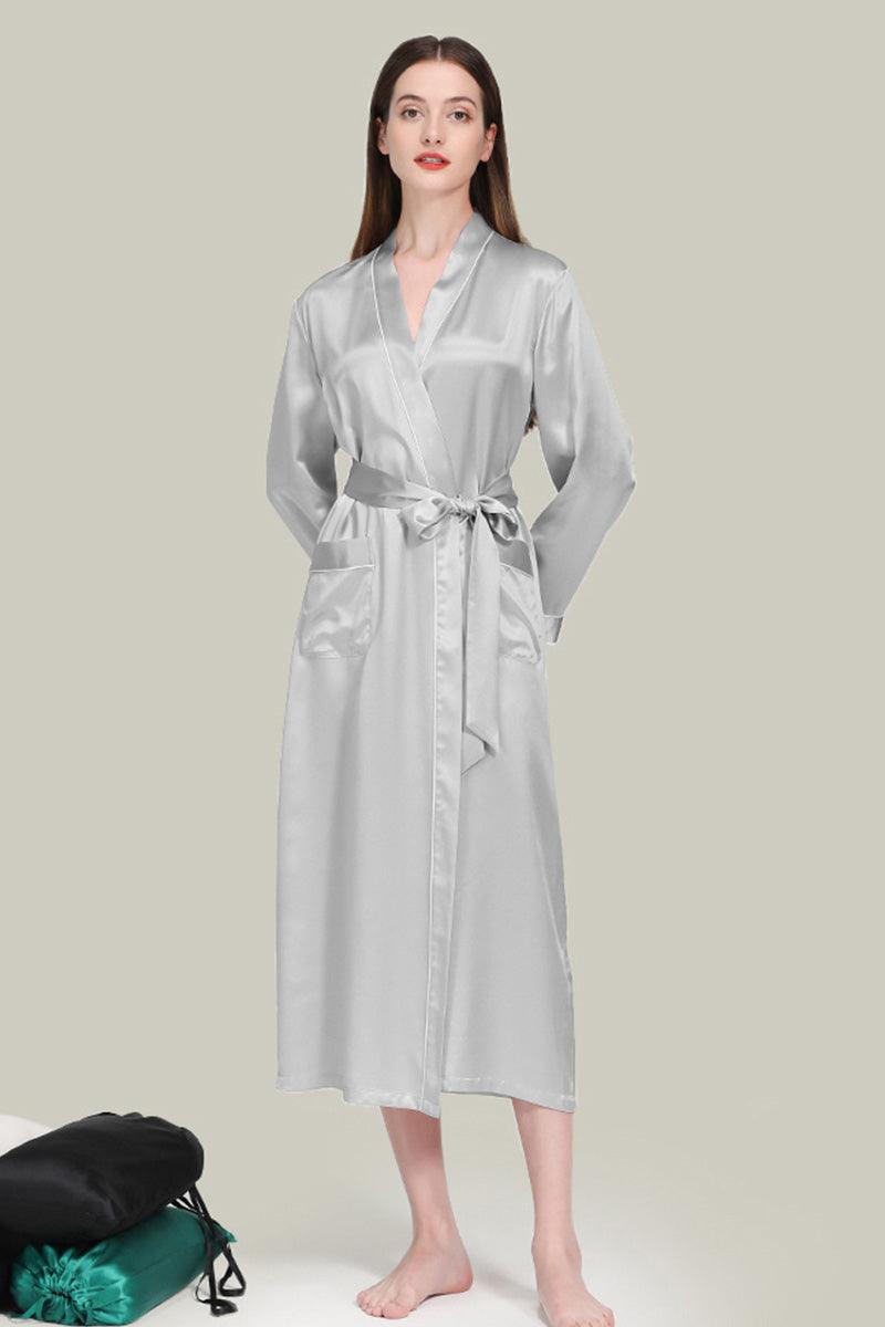Woman wearing silver Mulberry silk nightgown with sash belt, long sleeves, and relaxed fit