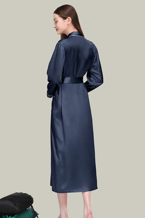 Woman wearing navy blue Mulberry Silk Nightgown with sash belt, long sleeves, and relaxed fit shown from the back