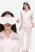 Woman wearing 100% mulberry silk striped long sleeve pajama set with matching eye mask and headband in soft pink and white.
