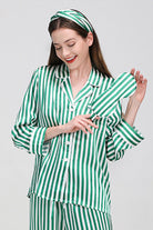 Woman wearing green and white striped mulberry silk long sleeve pajama set with matching headband and eye mask