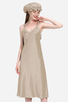 Woman wearing beige 100% mulberry silk elegant night dress with matching silk bonnet against white background